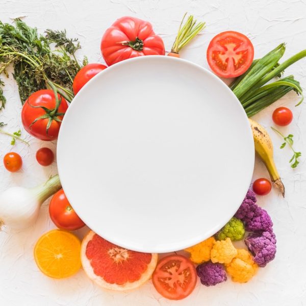 A plate surrounded by fruits and vegetables