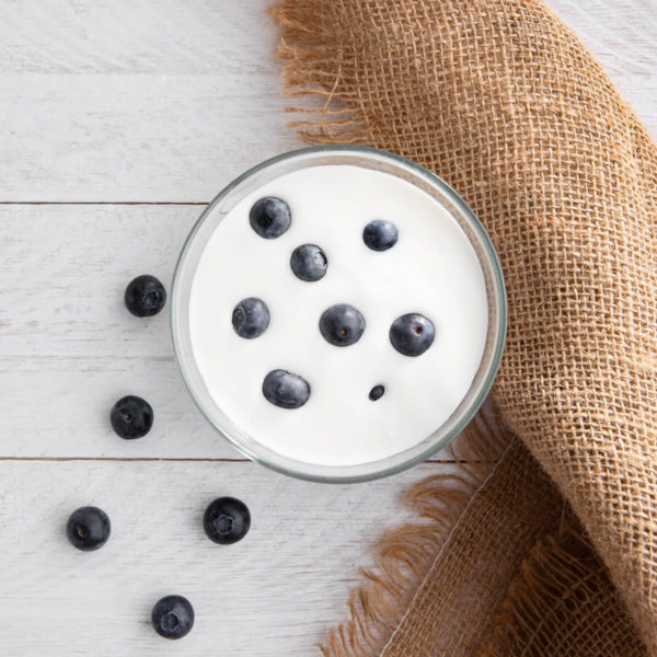 Kefir with blueberries in a glass on a table.